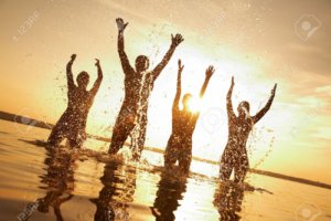 10588627-group-of-happy-young-people-dancing-and-spraying-at-the-beach-on-beautiful-summer-sunset-stock-photo